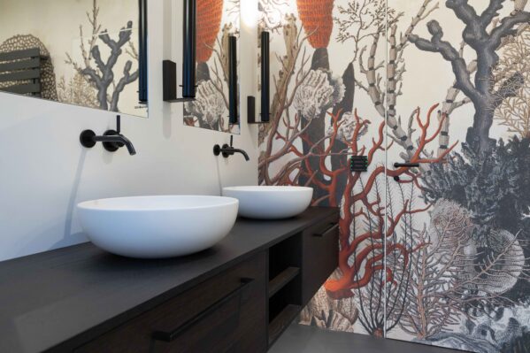 Bad mit orangener Korallentapete und fugenlosen Flächen